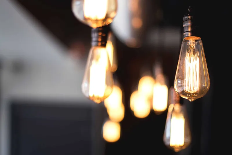 Plusieurs ampoules de style Edison vintage avec des filaments lumineux suspendues au plafond.